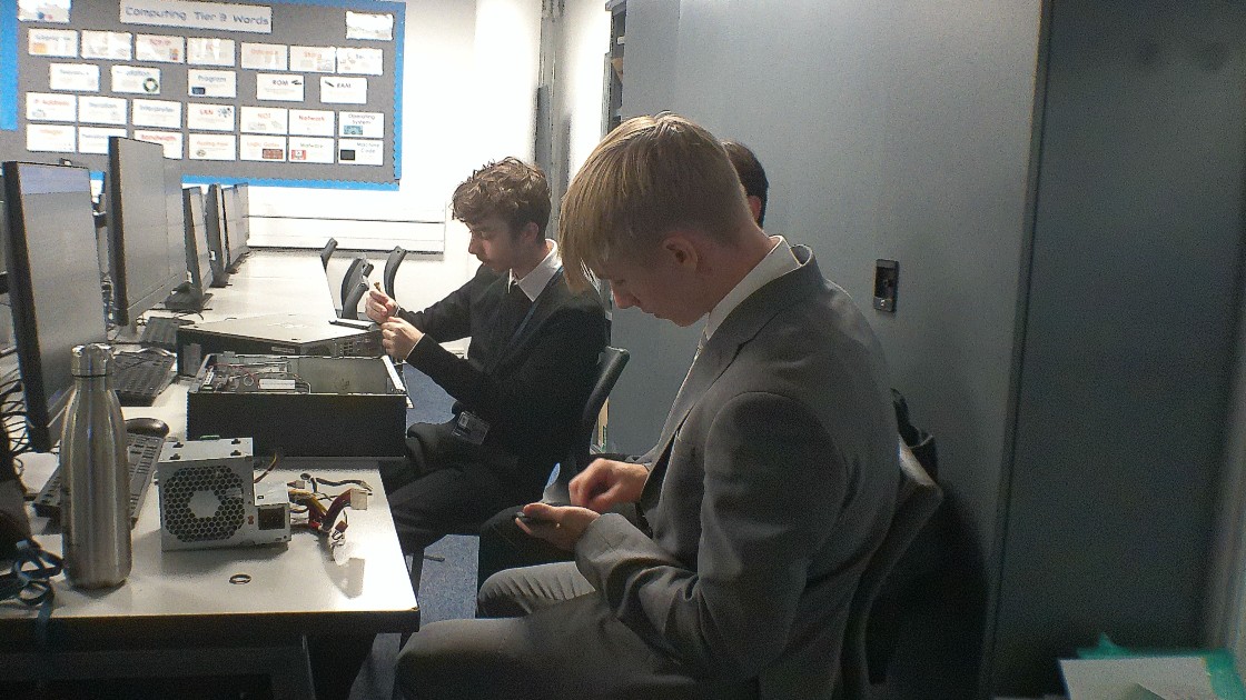 Students working on computer hardware in a classroom