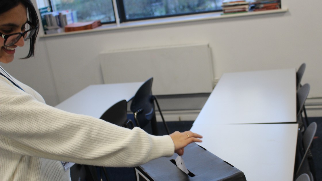 Student placing paper in a ballot box