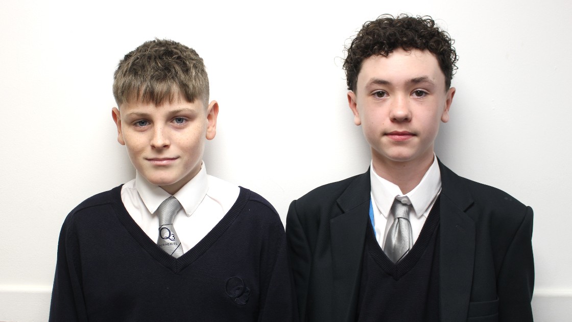 Two students in school uniforms standing side by side