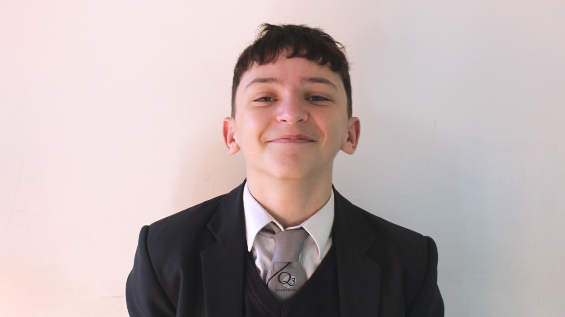 A student in a school uniform smiling