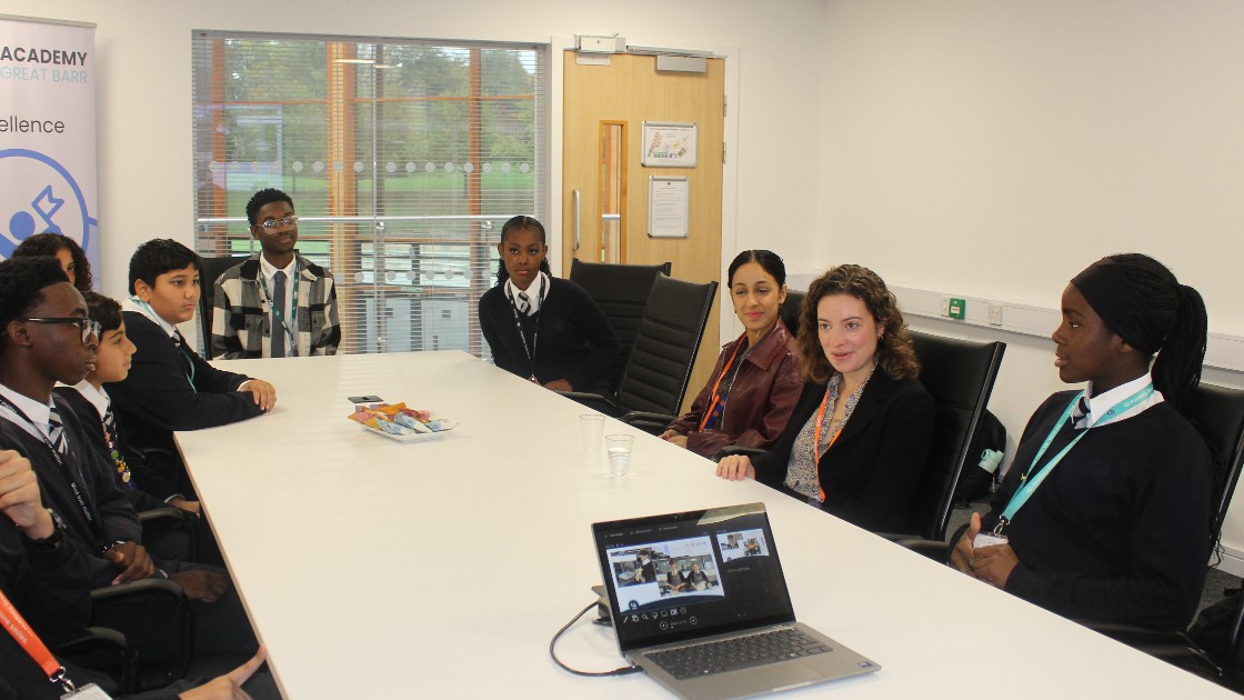 Students and a local MP in a meeting room discussing values around a conference table